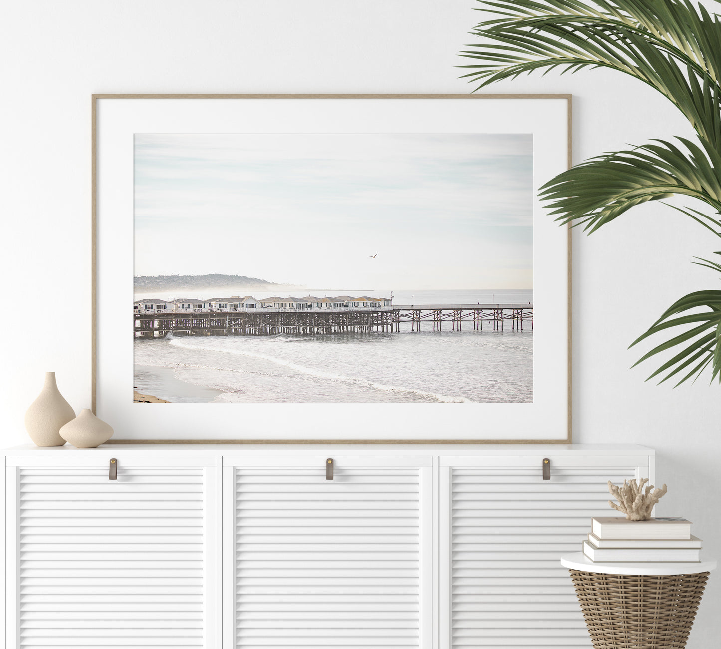 Landscape coastal photography of Crystal Pier in Pacific Beach, San Diego, extending into the calm ocean with gentle waves. Photograph in minimalist mock up
