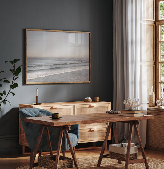 A wide landscape surf wall decor shot of Pacific Beach, showing many surfers in the water catching gentle waves under a hazy sky. This neutral surf print is great for beach art. Photograph in minimalist mock up.