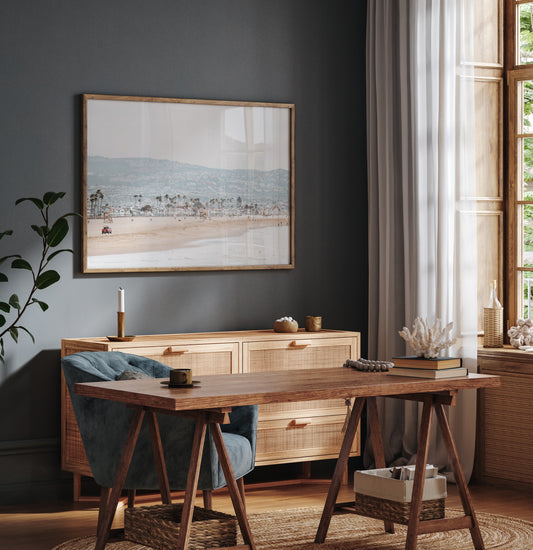 A wide landscape coastal photography shot of Newport Beach, California, featuring a red lifeguard truck, sandy beach, palm trees, and hazy mountains in the distance. Photograph in minimalist mock up.