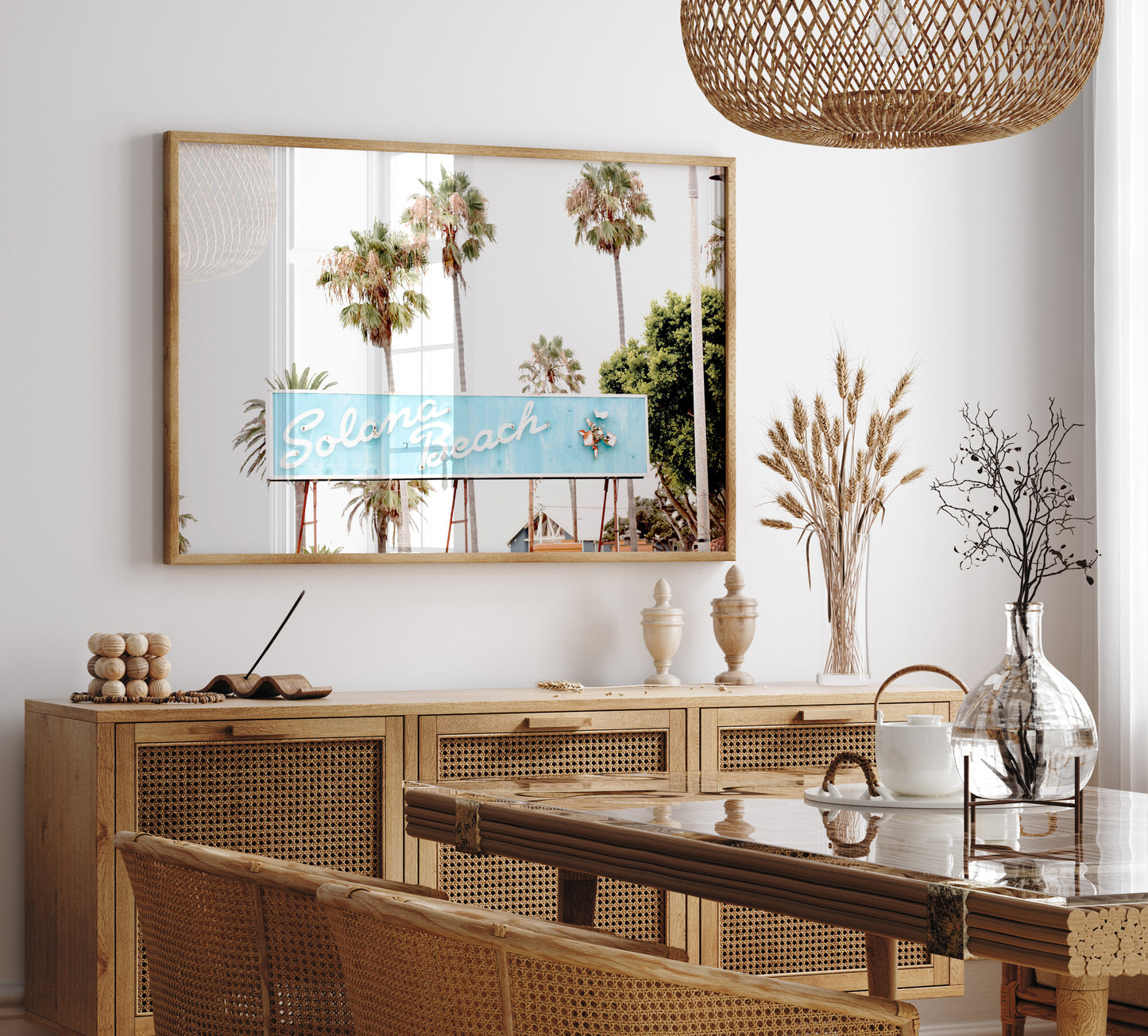 Colorful travel photography capturing the iconic 'Solana Beach' sign, a quintessential piece of Surf Signs San Diego art. The retro light blue sign, adorned with white cursive script and a unique steer head logo, is set against a backdrop of towering palm trees and a bright, hazy California sky. This Southern California surf beach sign evokes strong summer vibes and is perfect for coastal decor. Photograph in minimalist framed mock up.