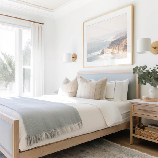 Fine art of Torrey Pines, San Diego California horizontal print of hazy high-angle landscape beach photography captures a light blue ocean meeting a sandy beach with many beach goers. To the right, tall tan and brown cliffs rise as iconic coastal scenery. Photograph in minimalist framed mock up.