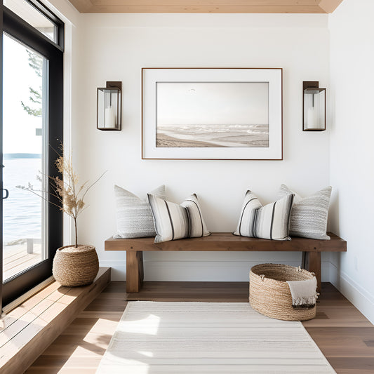 Minimalist ocean print featuring gentle ocean waves breaking on a sandy beach under a bright, hazy sky with a single bird in flight. A serene and neutral ocean print. Photograph in minimalist mock up.