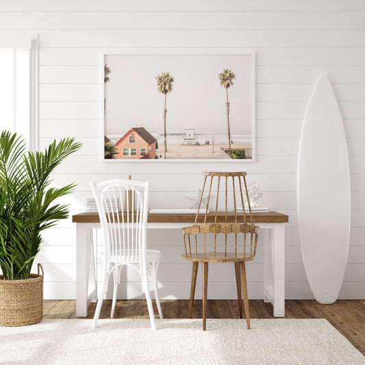Landscape beach photography of Oceanside, California, highlighting a beachfront house and a lifeguard tower with two tall palm trees and the ocean. Photograph in minimalist mock up.