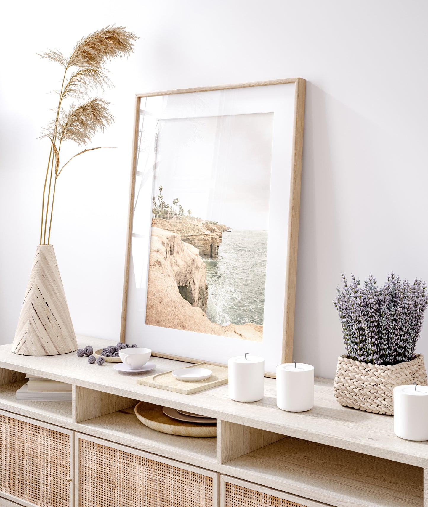 Fine art of Sunset Cliffs, San Diego California vertical print of hazy high-angle landscape beach photography captures a light blue ocean meeting tall tan, brown cliffs rise as iconic coastal scenery. Photograph in minimalist mock up.