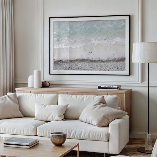 Horizontal surf print of a rocky beach next to foamy ocean waves. This surfing art captures a unique coastline. Photograph in minimalist mock up.