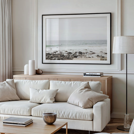 Landscape coastal photography of Salt Creek Beach with dark rocks on the shore and numerous surfers in the ocean. A neutral ocean print perfect for beach house decor. Photograph in minimalist mock up.