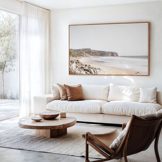 Minimalist ocean print of ocean waves with beach goers in the distance and large  sandy cliffs in the distance overlooking the seascape. Photograph in minimalist mock up.