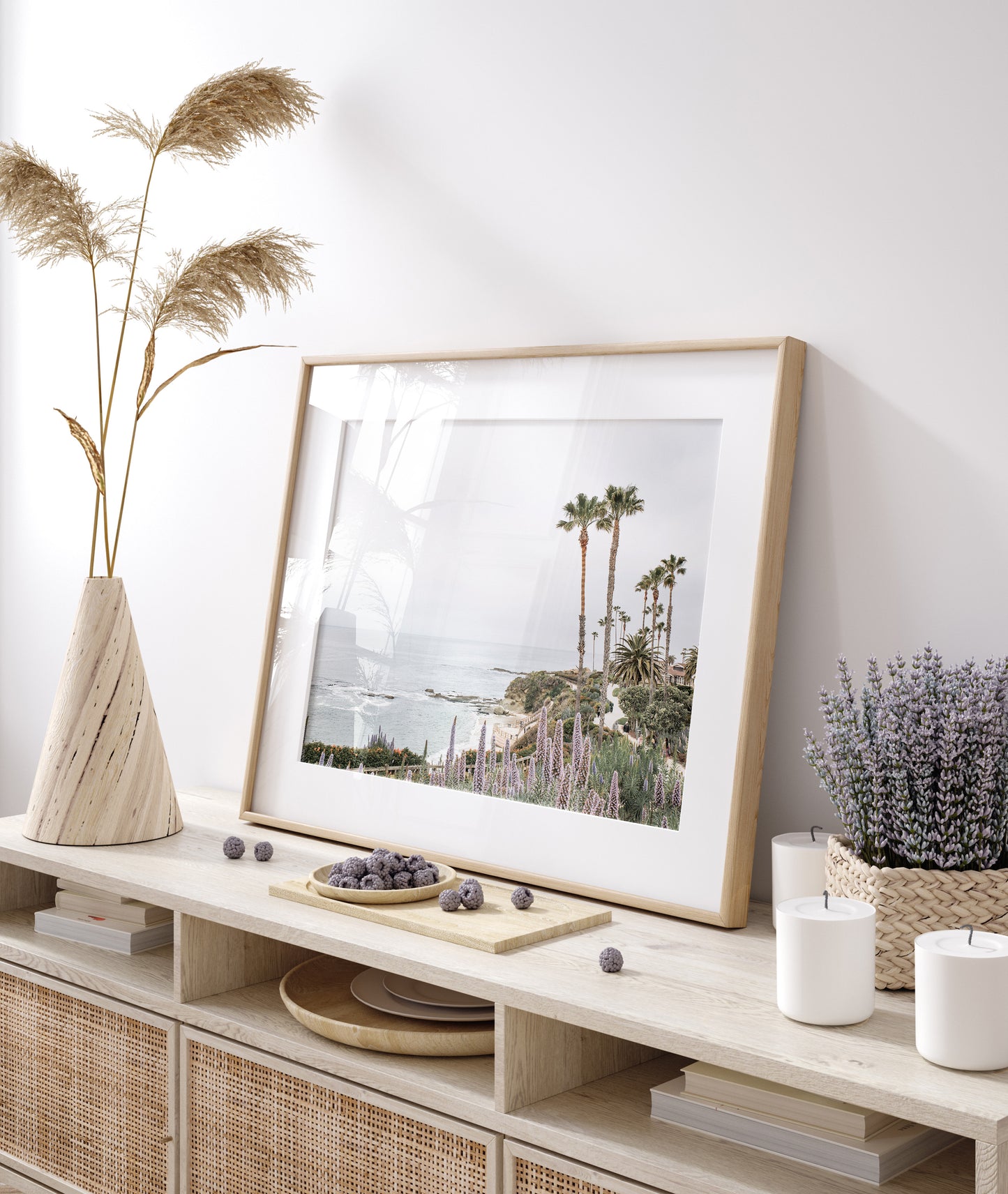 Horizontal coastal photography featuring a scenic view of the ocean with palm trees in the background, set against a white sky, located in Laguna California. Photograph in minimalist mock up.