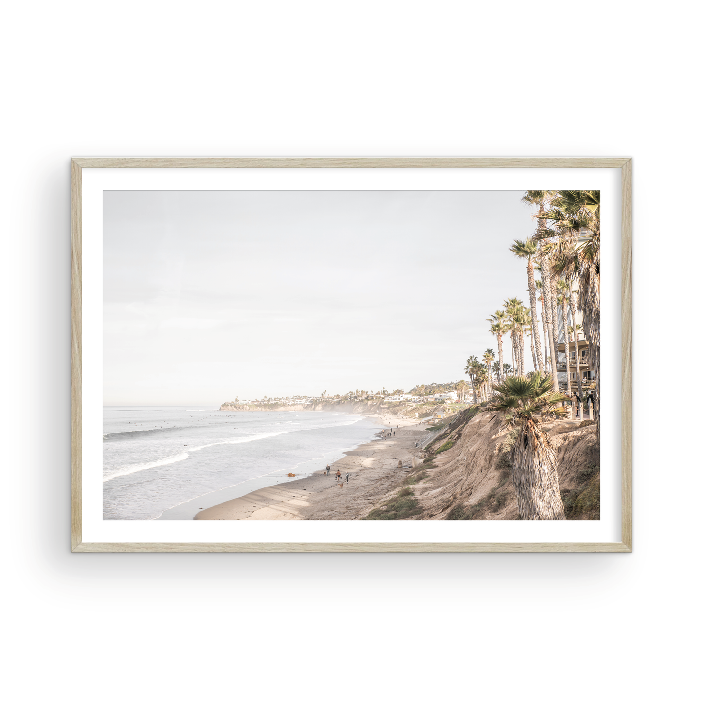 Horizontal, California coast print featuring a high vantage point overlooking Pacific Beach, with tall palm trees, a sandy beach, and the ocean. This coastal print offers a beautiful seascape. Photograph in minimalist mock up.