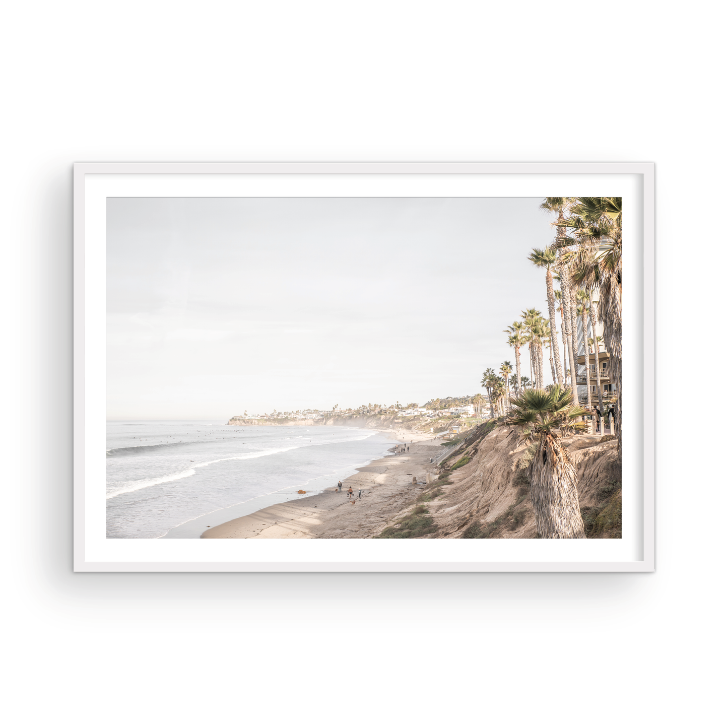 Horizontal, California coast print featuring a high vantage point overlooking Pacific Beach, with tall palm trees, a sandy beach, and the ocean. This coastal print offers a beautiful seascape. Photograph in minimalist mock up.