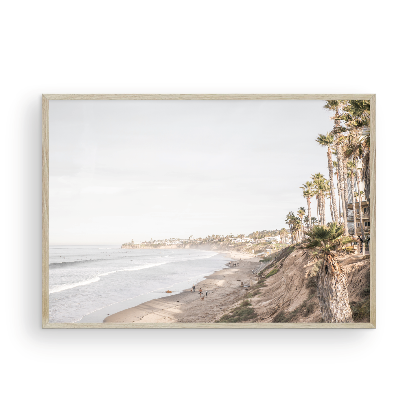 Horizontal, California coast print featuring a high vantage point overlooking Pacific Beach, with tall palm trees, a sandy beach, and the ocean. This coastal print offers a beautiful seascape. Photograph in minimalist mock up.