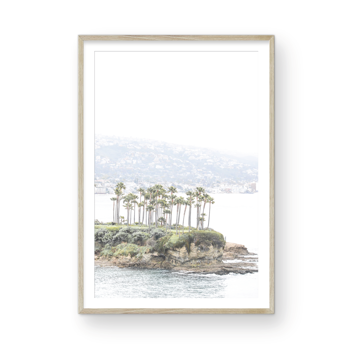 Vertical coastal photography of Laguna Beach, San Diego, featuring a fine art giclee print featuring palm trees on a small island in a body of water. Photograph in minimalist mock up.