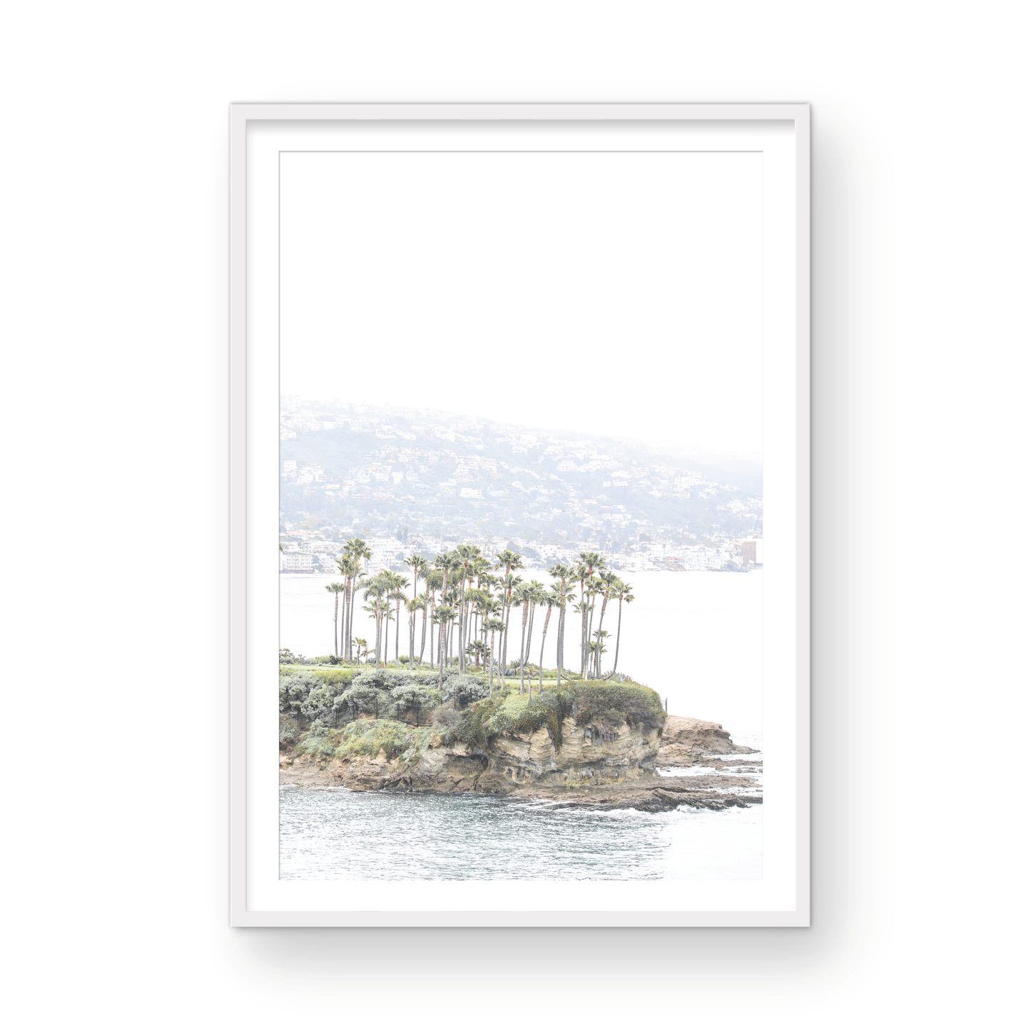 Vertical coastal photography of Laguna Beach, San Diego, featuring a fine art giclee print featuring palm trees on a small island in a body of water. Photograph in minimalist mock up.