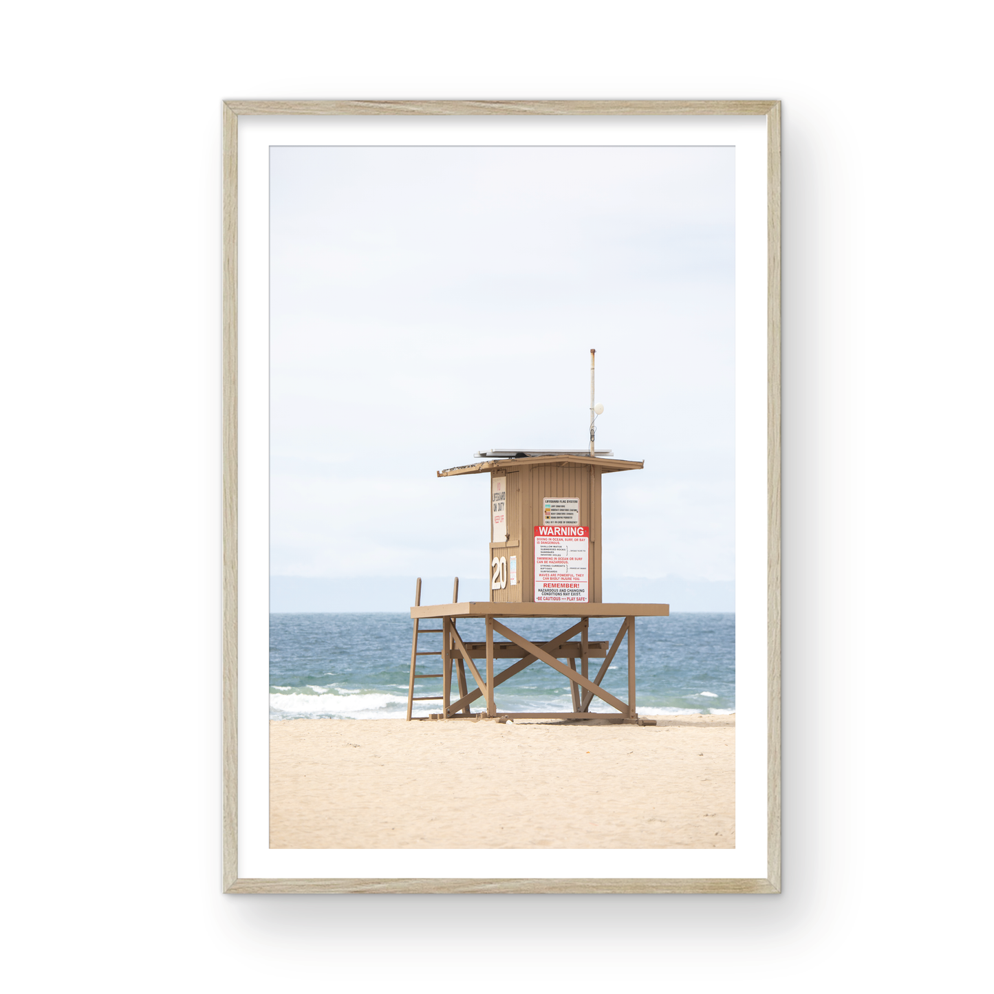A wide landscape coastal photography view of Newport Beach in Southern California, featuring a lifeguard tower and walls on the beach. Photograph in minimalist mock up.