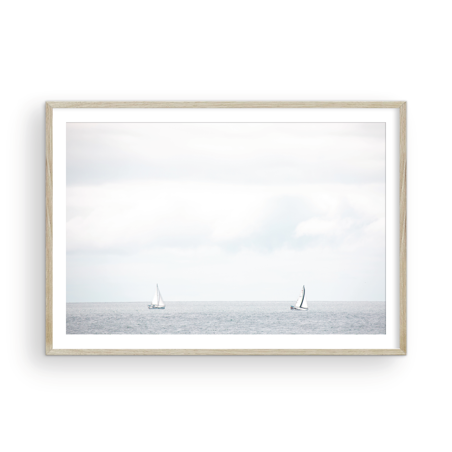 Minimalist ocean print featuring two sailboats on a calm ocean under a vast, bright sky. This serene seascape is ideal for coastal, nautical theme wall art. Photograph in minimalist mock up