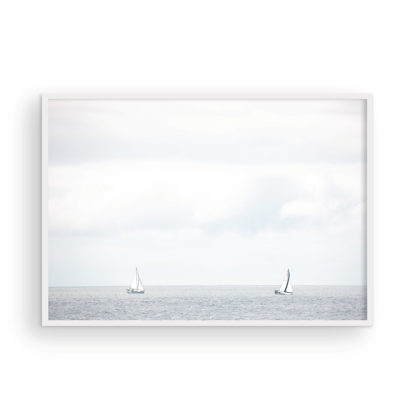 Minimalist ocean print featuring two sailboats on a calm ocean under a vast, bright sky. This serene seascape is ideal for coastal, nautical theme wall art. Photograph in minimalist mock up
