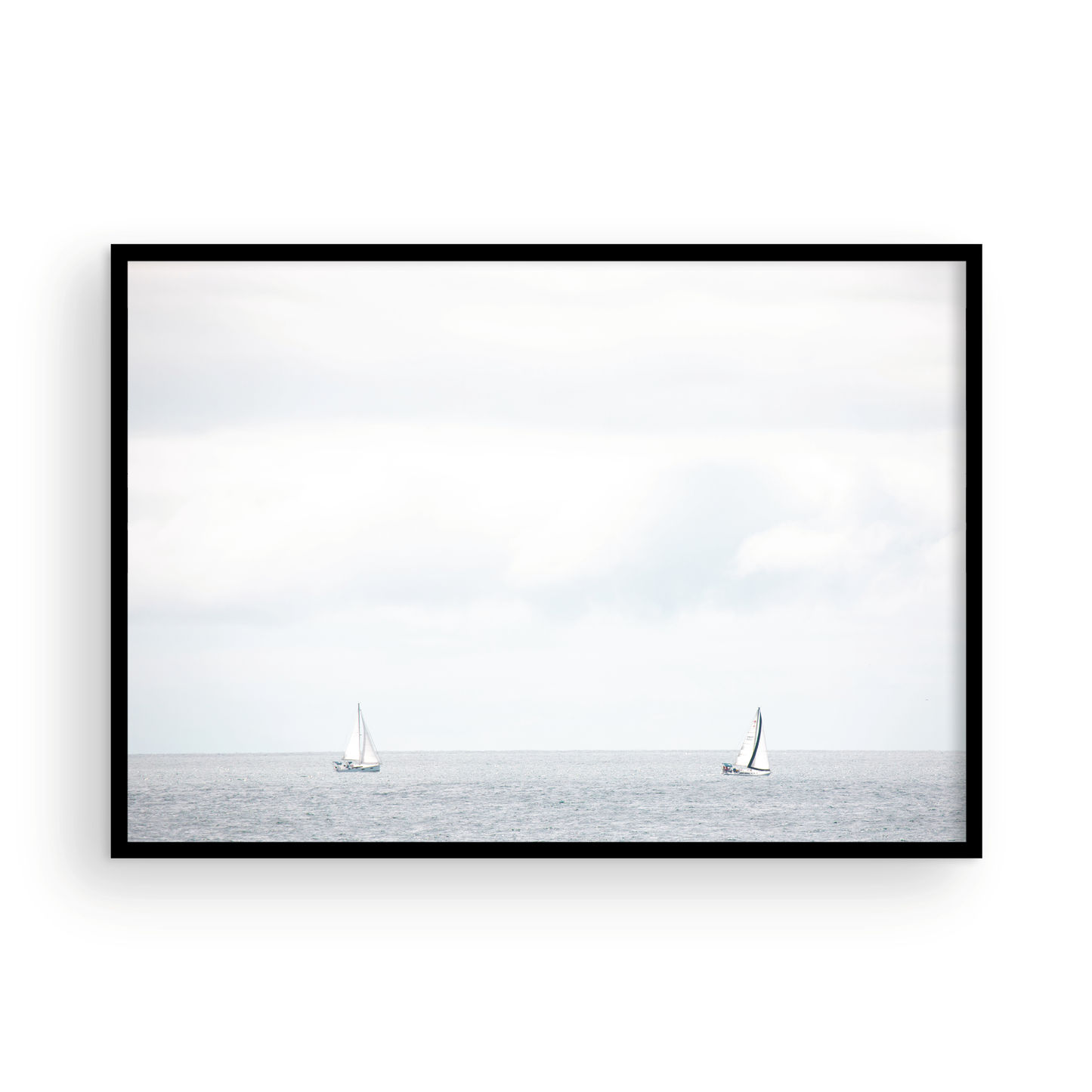 Minimalist ocean print featuring two sailboats on a calm ocean under a vast, bright sky. This serene seascape is ideal for coastal, nautical theme wall art. Photograph in minimalist mock up
