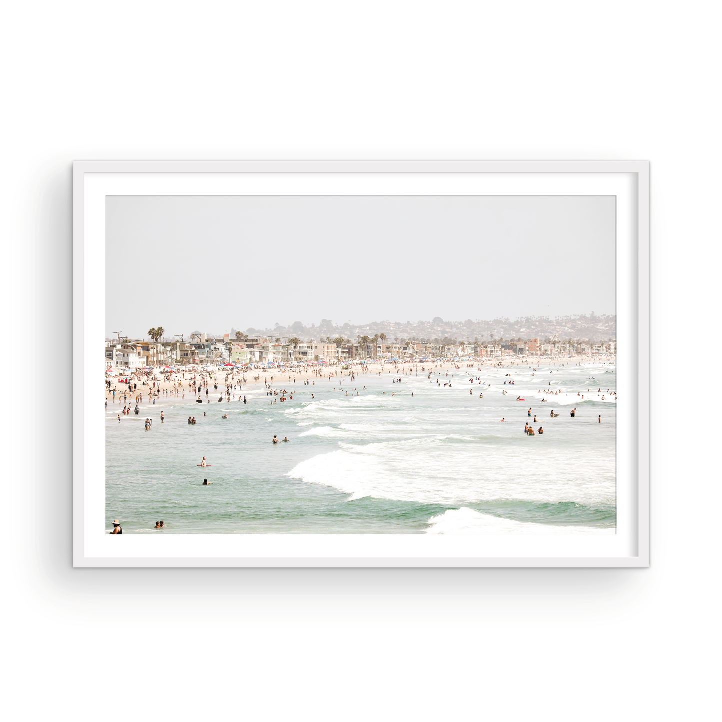 Landscape beach photography of a busy San Diego public beach with many people in the sand and ocean waves, a true summer vibes scene. Photograph in minimalist mock up.