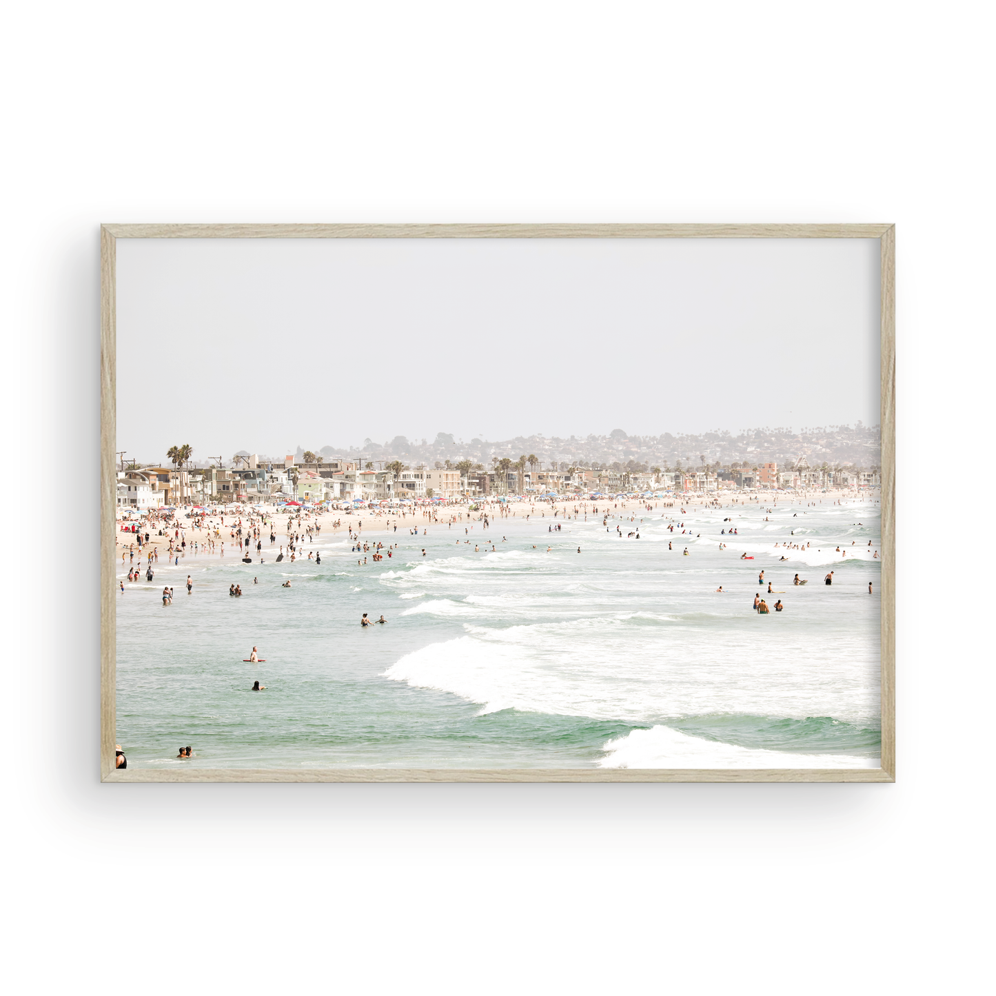 Landscape beach photography of a busy San Diego public beach with many people in the sand and ocean waves, a true summer vibes scene. Photograph in minimalist mock up.