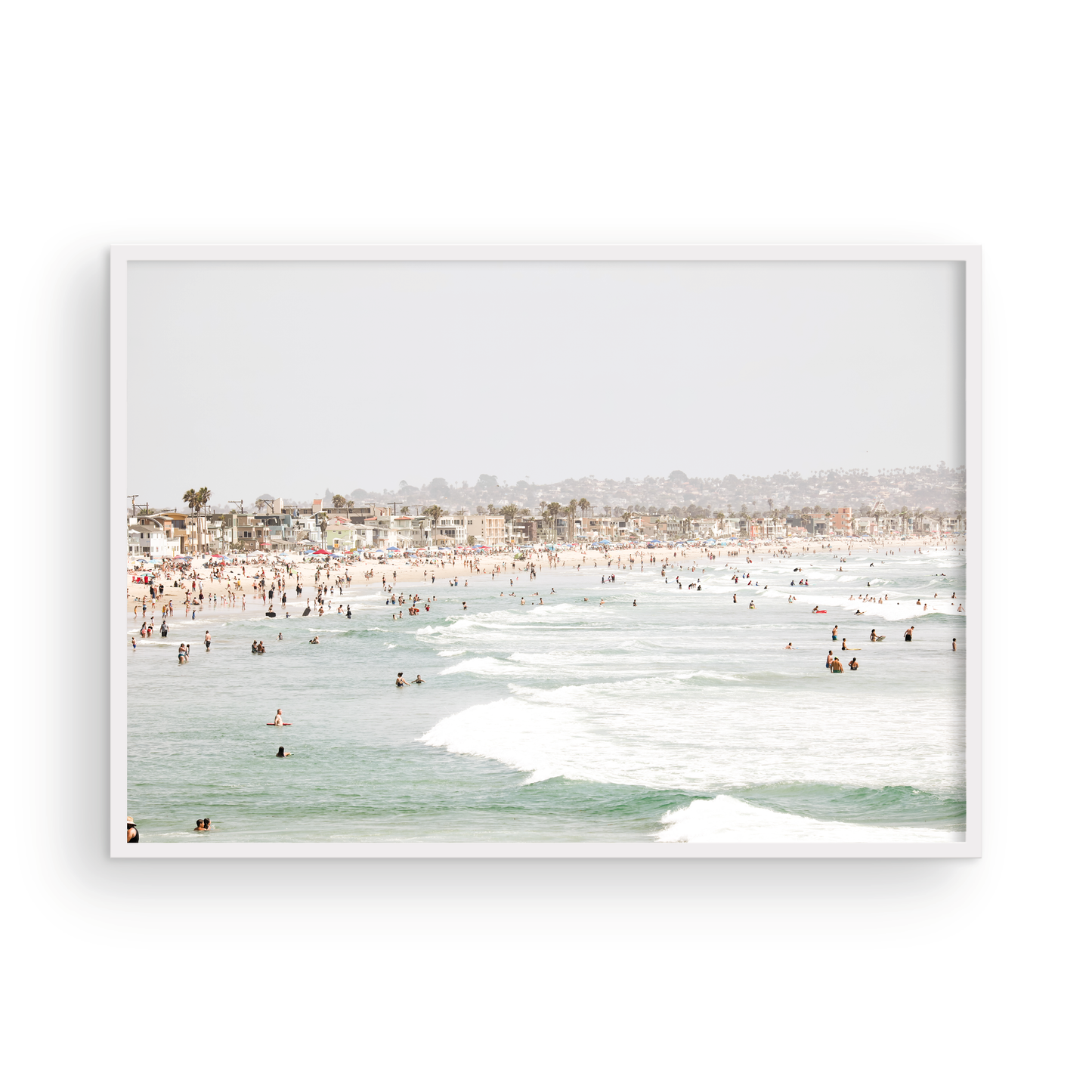 Landscape beach photography of a busy San Diego public beach with many people in the sand and ocean waves, a true summer vibes scene. Photograph in minimalist mock up.