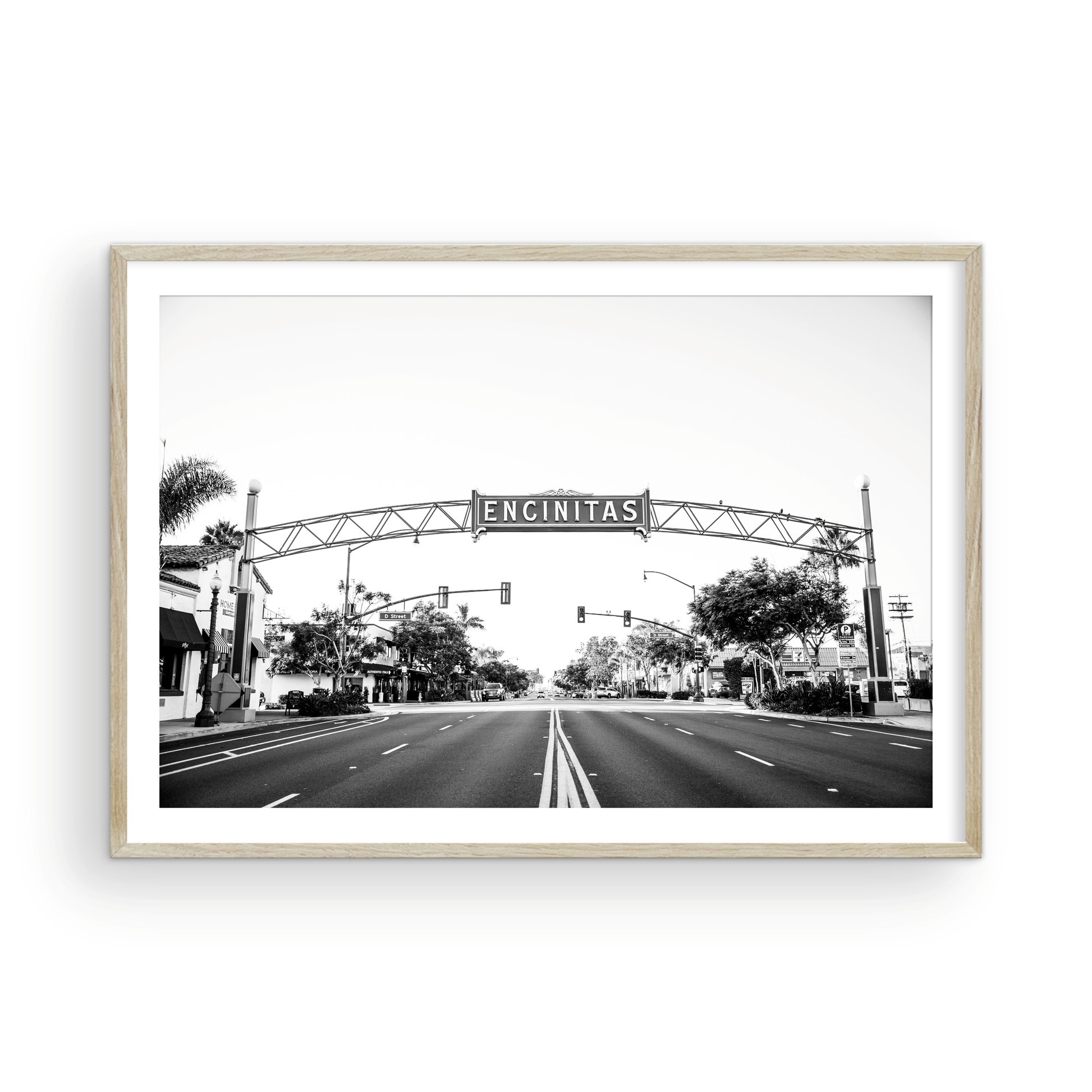 A black and white photograph of a street sign that reads 'Encinitas' with a background of a city street. Photograph in minimalist mock up.