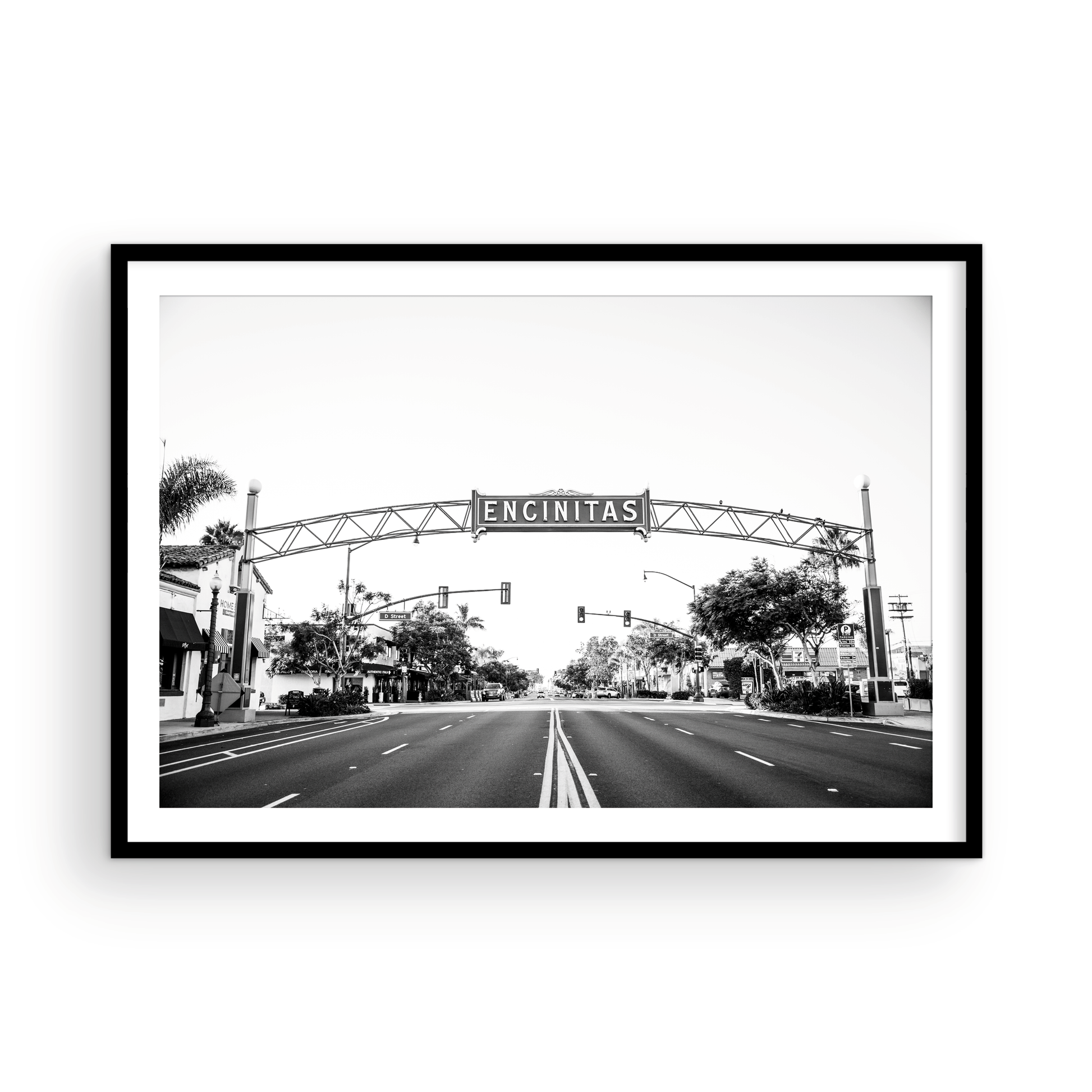 A black and white photograph of a street sign that reads 'Encinitas' with a background of a city street. Photograph in minimalist mock up.