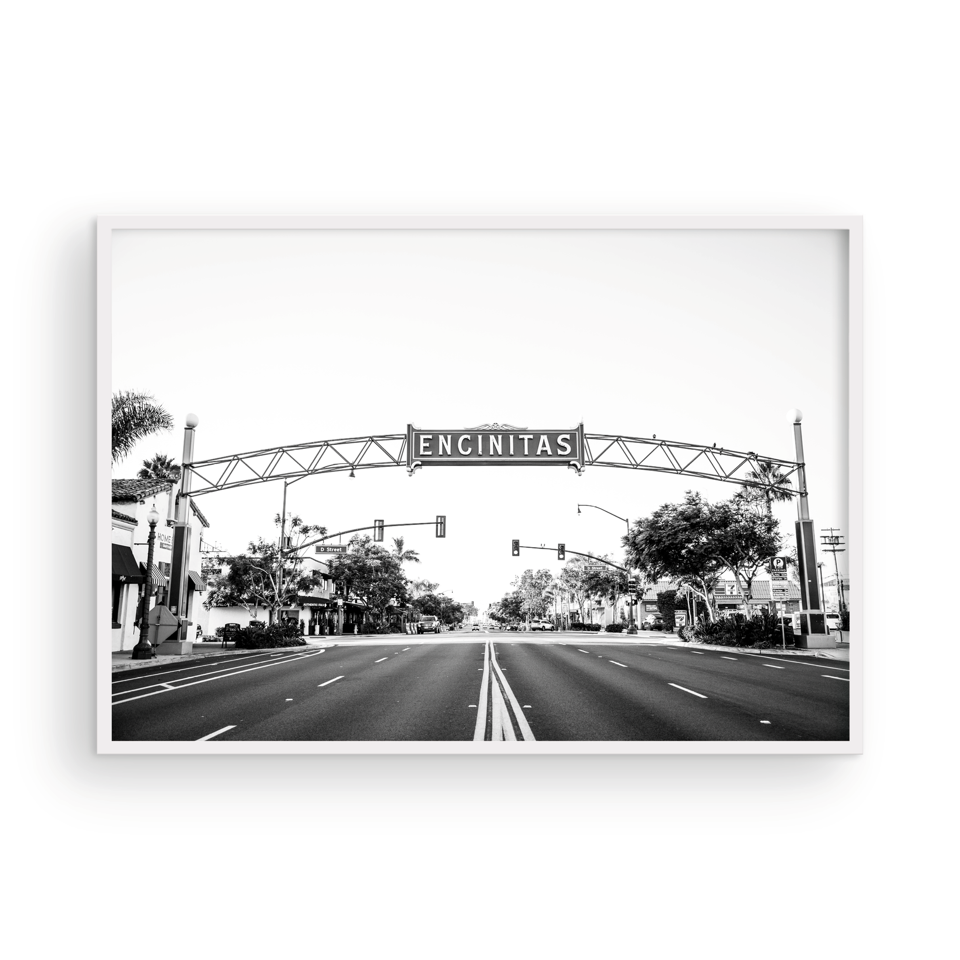 A black and white photograph of a street sign that reads 'Encinitas' with a background of a city street. Photograph in minimalist mock up.