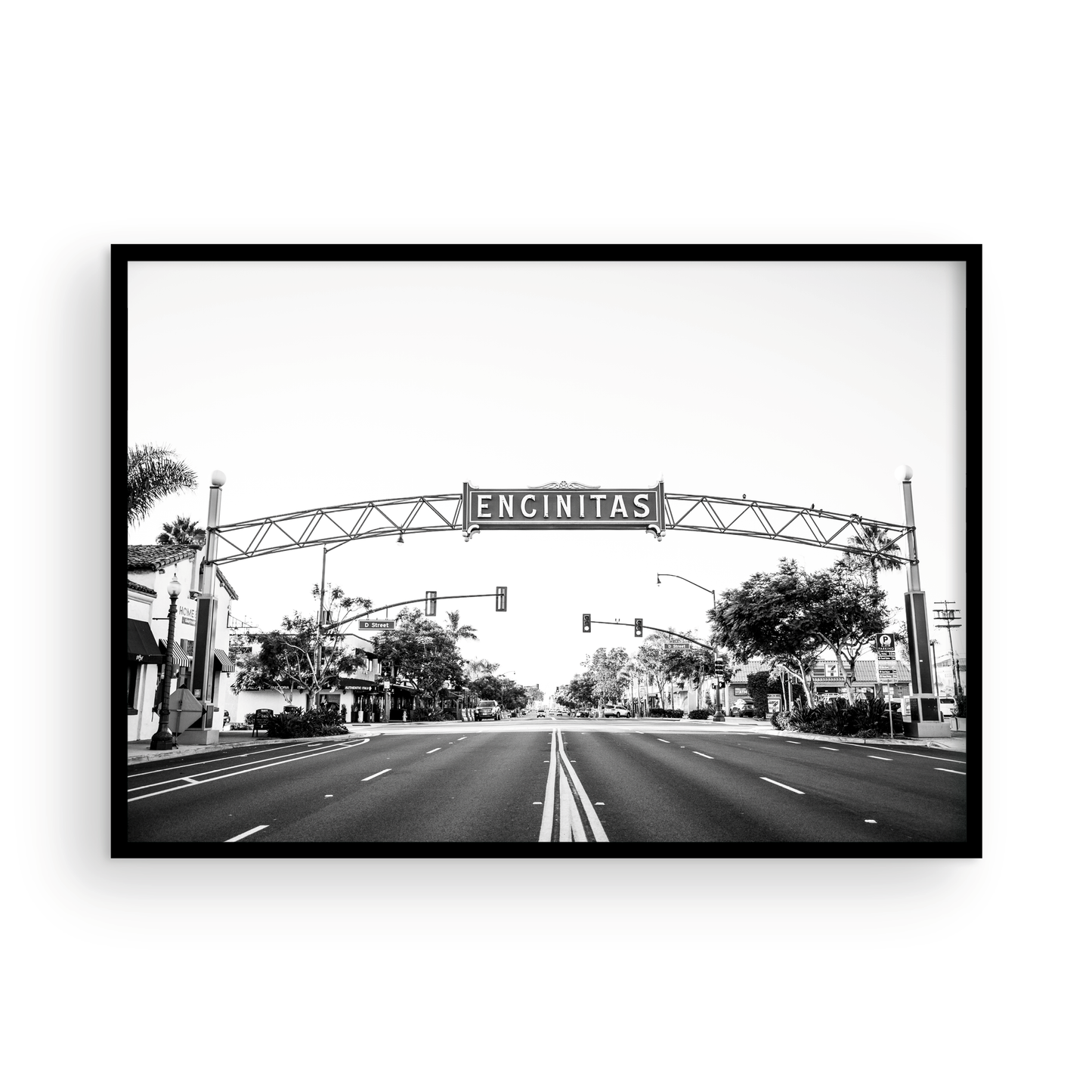 A black and white photograph of a street sign that reads 'Encinitas' with a background of a city street. Photograph in minimalist mock up.