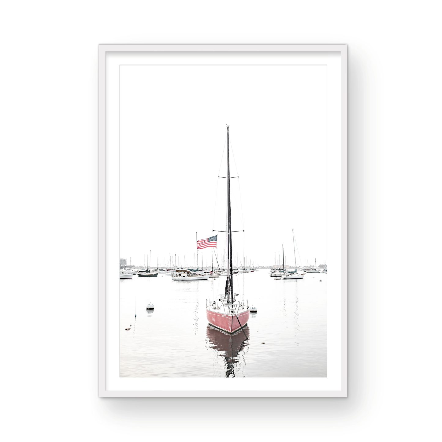 A vertical San Diego print featuring a lone red sailboat with an American flag, anchored in a calm San Diego harbor. This minimalist ocean print captures the essence of coastal photography and is perfect for modern coastal decor. Photograph in minimalist mock up.