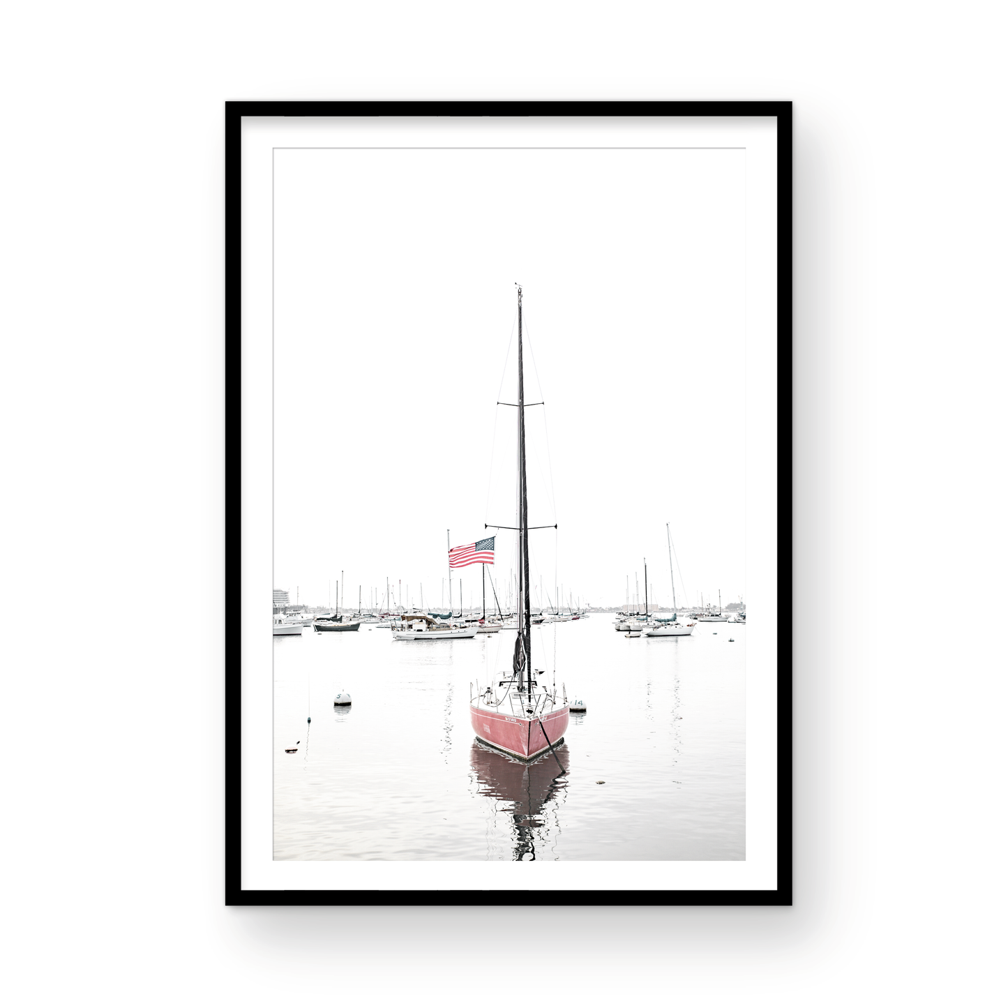 A vertical San Diego print featuring a lone red sailboat with an American flag, anchored in a calm San Diego harbor. This minimalist ocean print captures the essence of coastal photography and is perfect for modern coastal decor. Photograph in minimalist mock up.