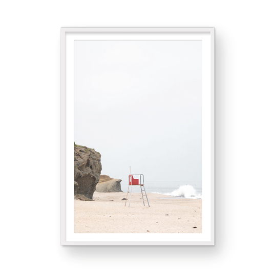 Vertical coastal photography featuring a red and white lifeguard chair and a calm ocean background, located in Laguna California. Photograph in minimalist mock up.