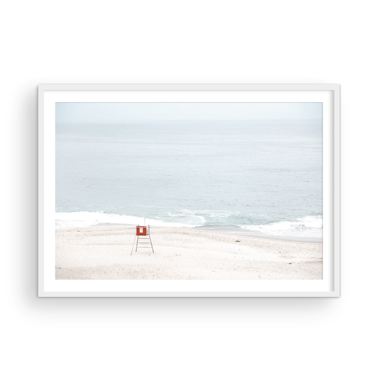 Horizontal coastal photography featuring a red and white lifeguard chair and a calm ocean background, located in Laguna California. Photograph in minimalist mock up.