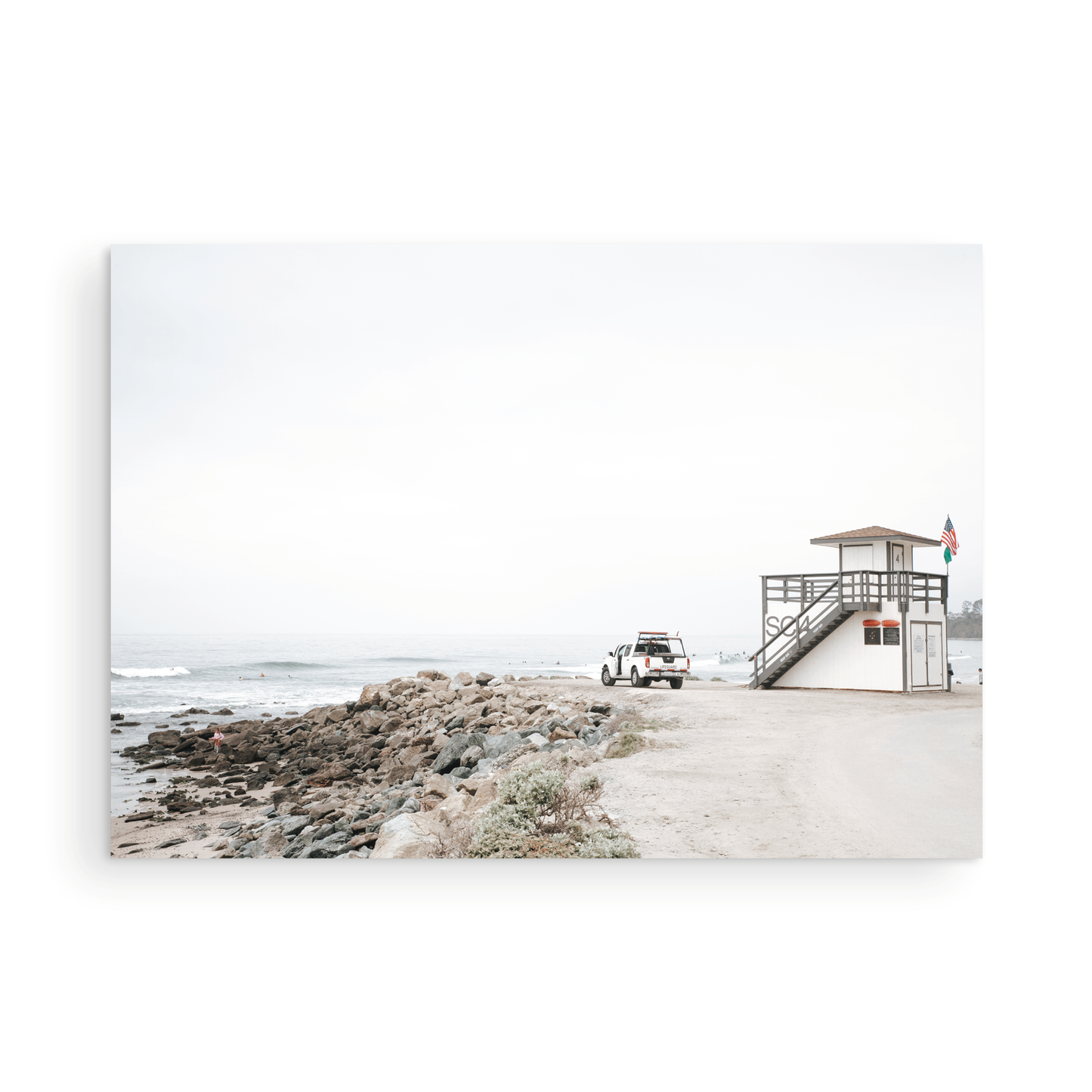 Landscape beach photography of Salt Creek Beach, with lifeguard tower SC 4 in the foreground, and many people enjoying the beach and ocean in the distance. A beach vibes print. Photograph in minimalist mock up.