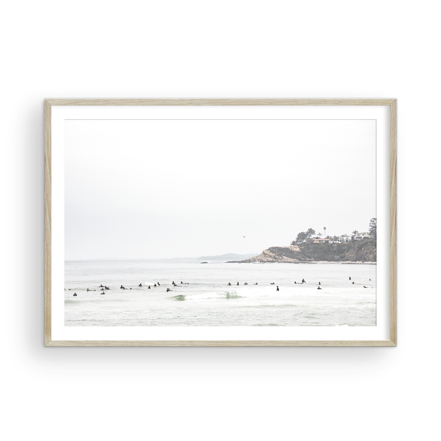 Landscape surf wall decor showing many surfers waiting for waves in the ocean at Salt Creek Beach, with a distant cliffside. This print captures the surf vibes of Southern California. Photograph in minimalist mock up.