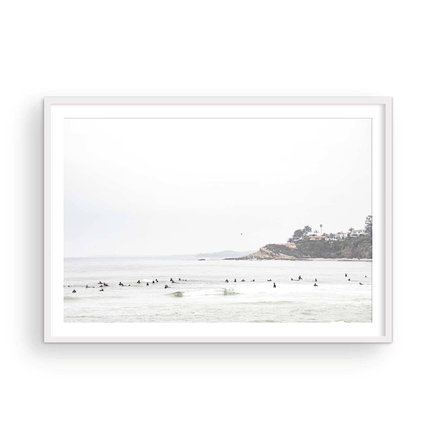 Landscape surf wall decor showing many surfers waiting for waves in the ocean at Salt Creek Beach, with a distant cliffside. This print captures the surf vibes of Southern California. Photograph in minimalist mock up.