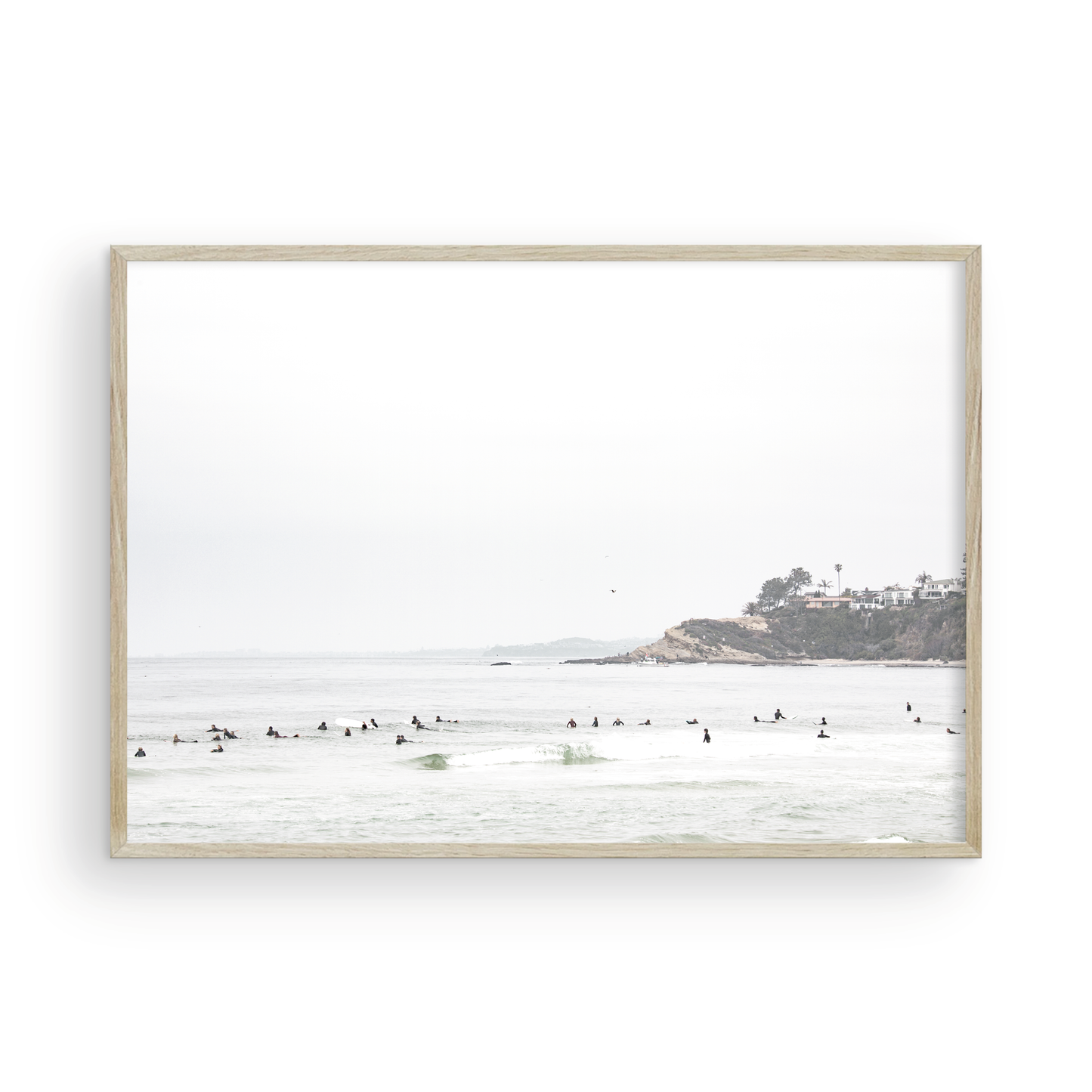 Landscape surf wall decor showing many surfers waiting for waves in the ocean at Salt Creek Beach, with a distant cliffside. This print captures the surf vibes of Southern California. Photograph in minimalist mock up.
