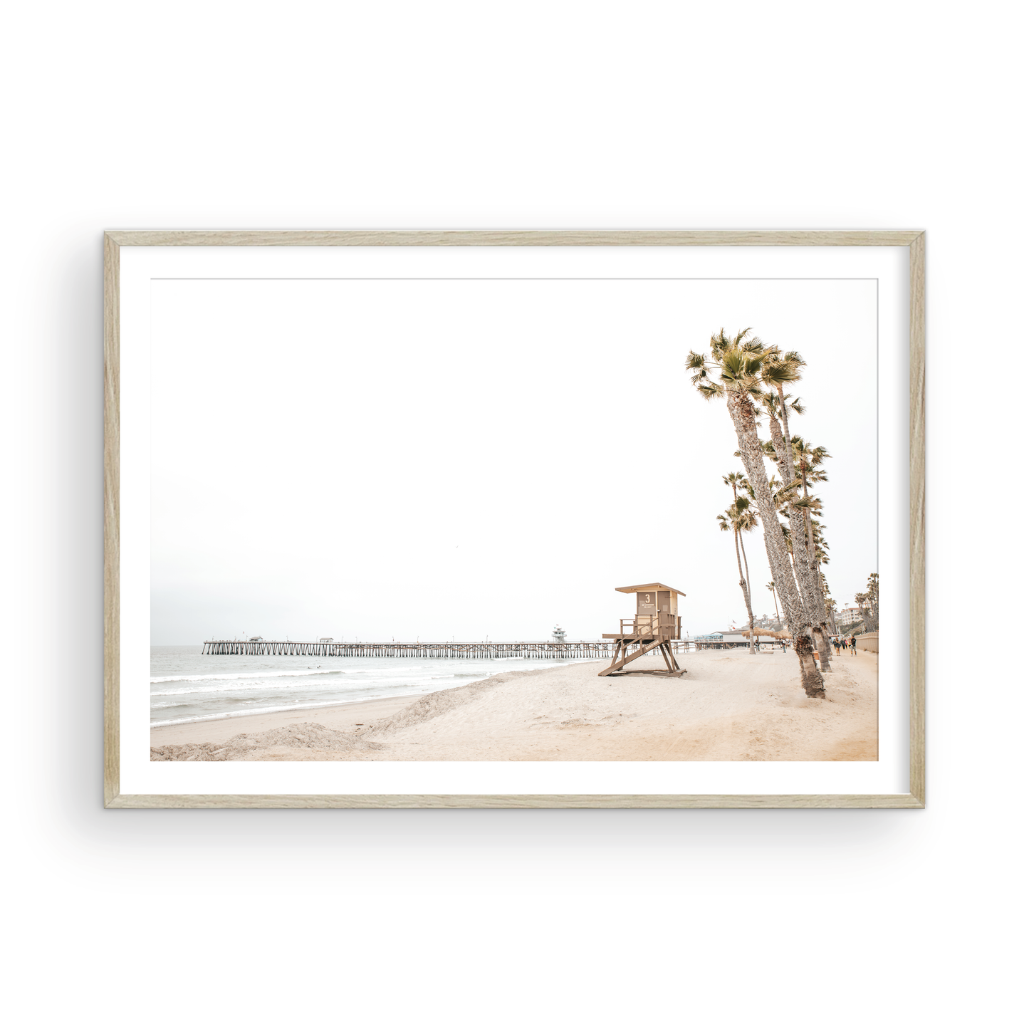 A wide landscape coastal photography view of San Clemente State Beach in Southern California, featuring a row of tall palm trees, a lifeguard tower, and people enjoying the calm beach. This image evokes Summer Vibes Wall Art and tropical beach print aesthetics. Photograph in minimalist mock up.