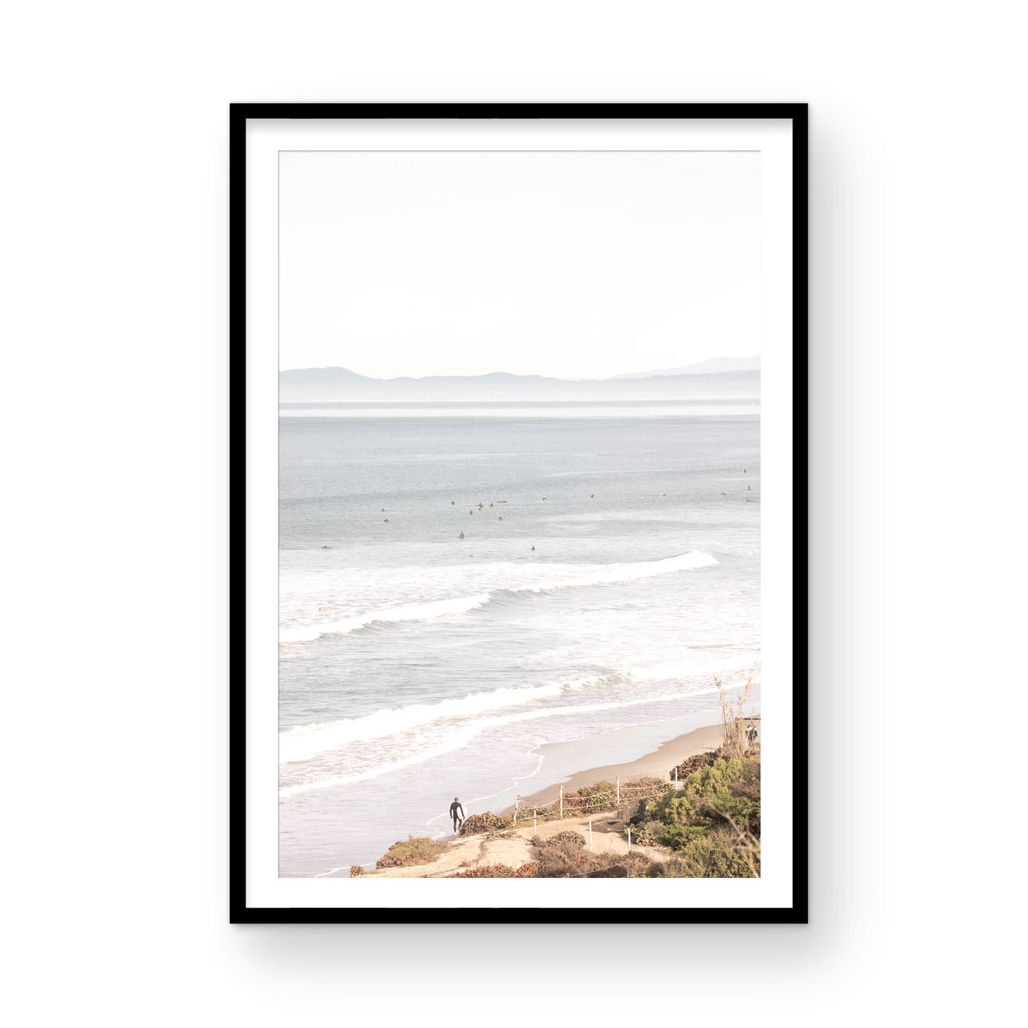 Minimalist ocean print of ocean waves with surfers in the distance and a sandy hillside in the foreground. Photograph in minimalist mock up.