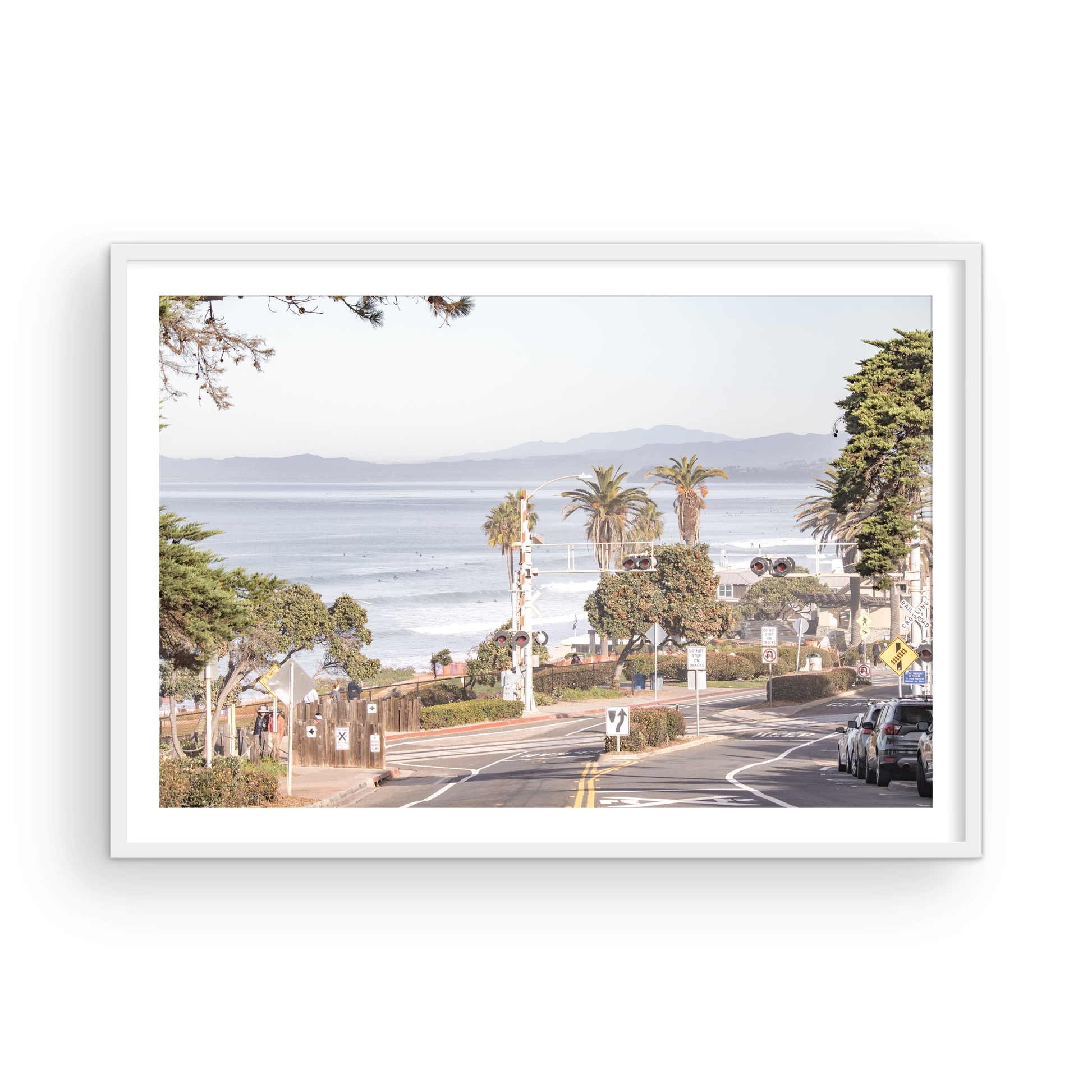 Coastal fine art photography print featuring a scenic view of a coastal road with palm trees, ocean in the background. Photograph in minimalist mock up.