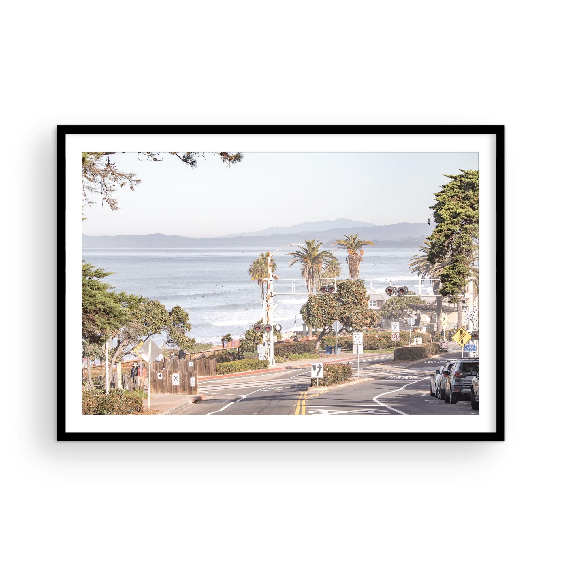 Coastal fine art photography print featuring a scenic view of a coastal road with palm trees, ocean in the background. Photograph in minimalist mock up.