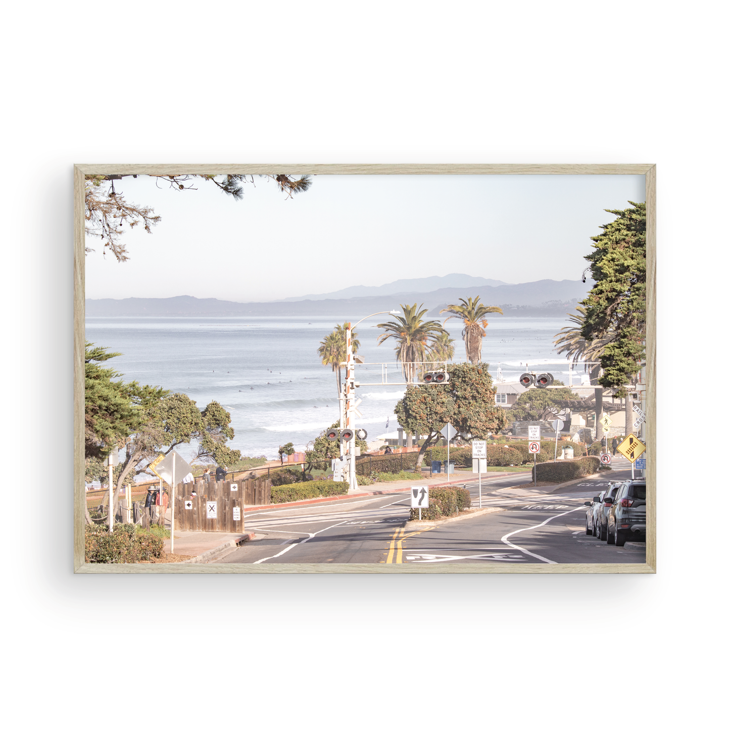 Coastal fine art photography print featuring a scenic view of a coastal road with palm trees, ocean in the background. Photograph in minimalist mock up.