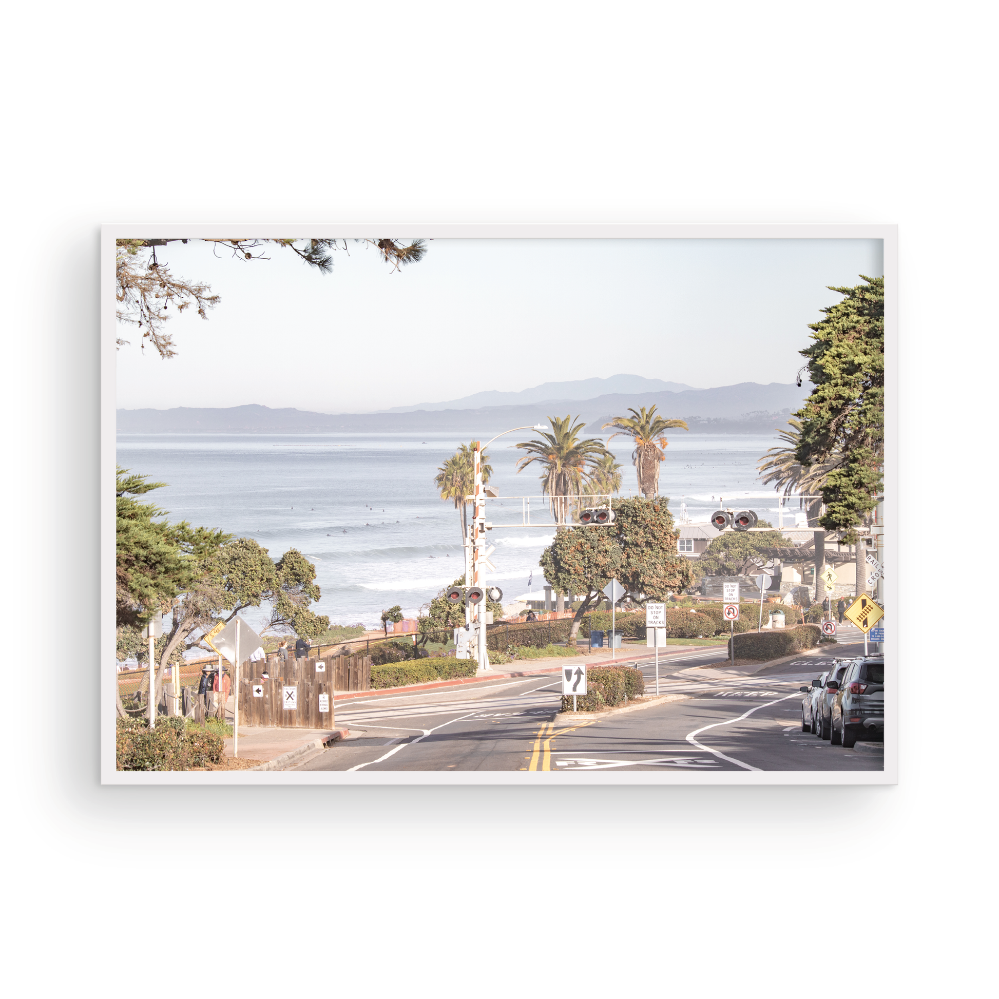 Coastal fine art photography print featuring a scenic view of a coastal road with palm trees, ocean in the background. Photograph in minimalist mock up.