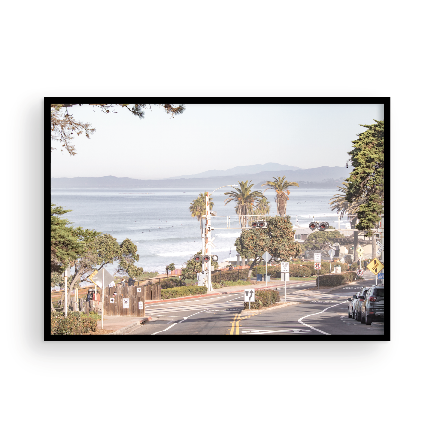 Coastal fine art photography print featuring a scenic view of a coastal road with palm trees, ocean in the background. Photograph in minimalist mock up.