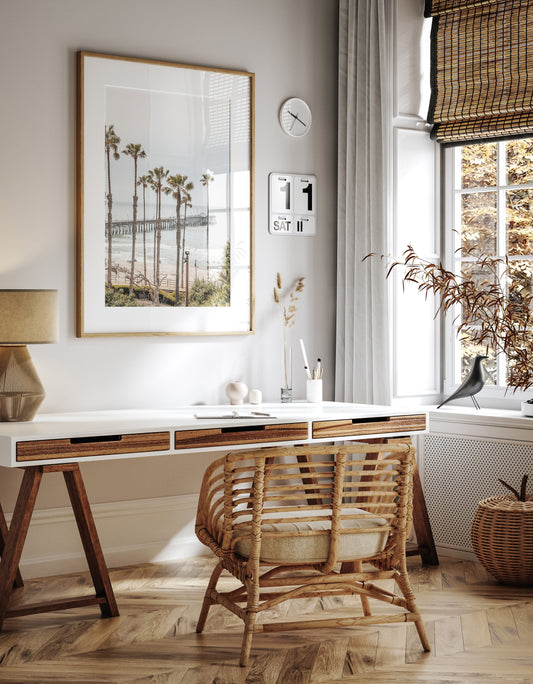 A vertical landscape coastal photography shot of the San Clemente Pier from behind a lush line of tall palm trees. This beachscape print highlights the California coast and is ideal for large beach art or a beach theme wall decor, with subtle ocean waves. Photograph in minimalist mock up.