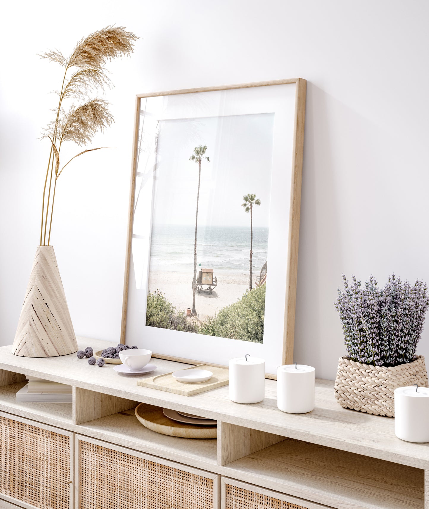 Vertical beach wall art featuring a lifeguard tower nestled between two tall palm trees on a sunny California beach, capturing a serene beach vibe. Photograph in minimalist mock up.