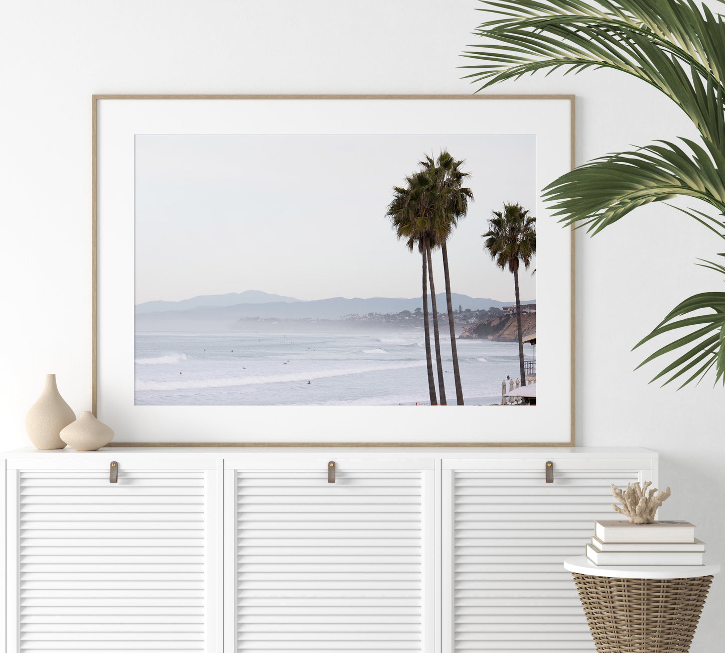 Landscape San Diego beach print showing a seascape with gentle ocean waves in the water and palm trees in the foreground. Photograph in minimalist mock up.