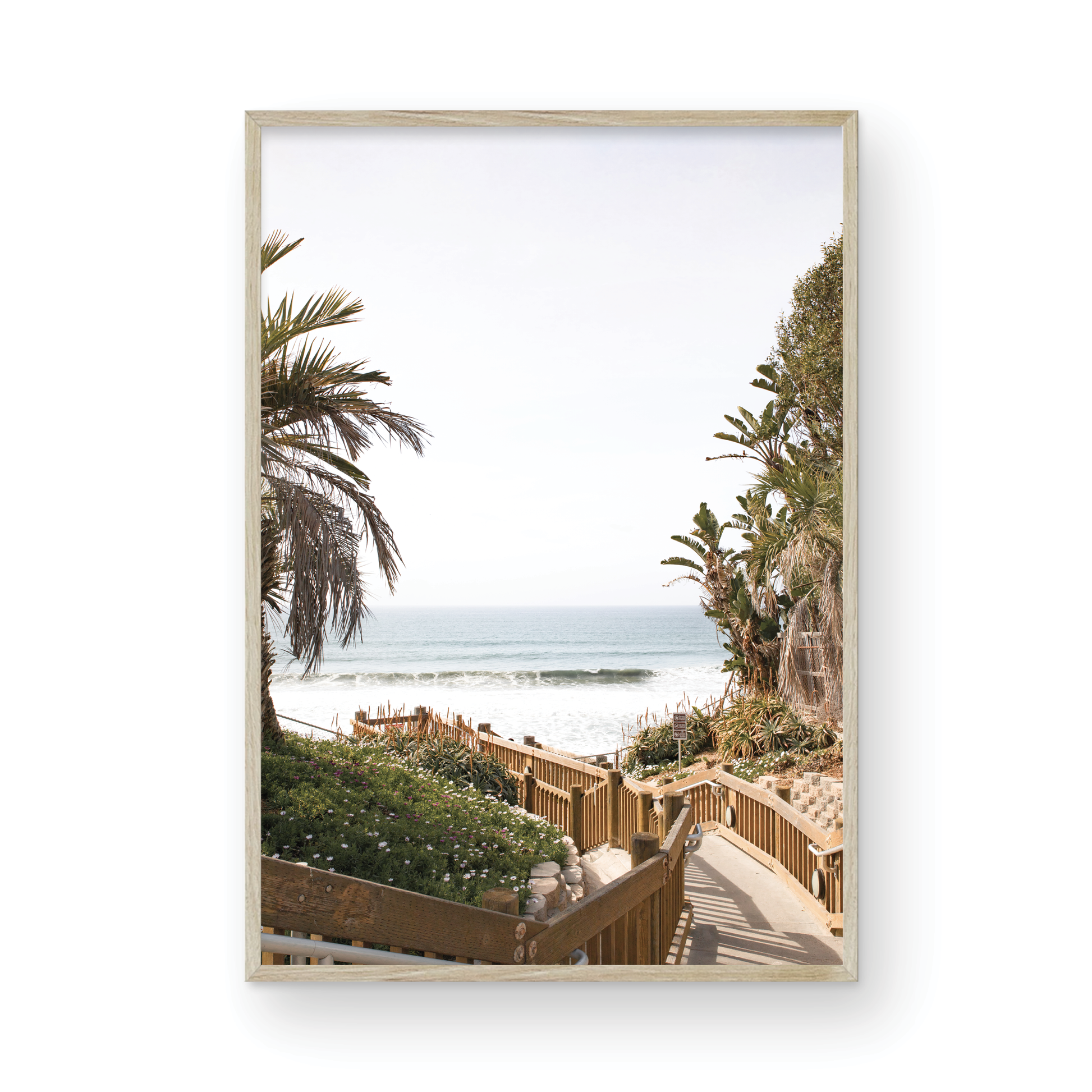 Vertical coastal wall print featuring a stairway leading down to a beach with palm trees and ocean view. Photograph in minimalist mock up.