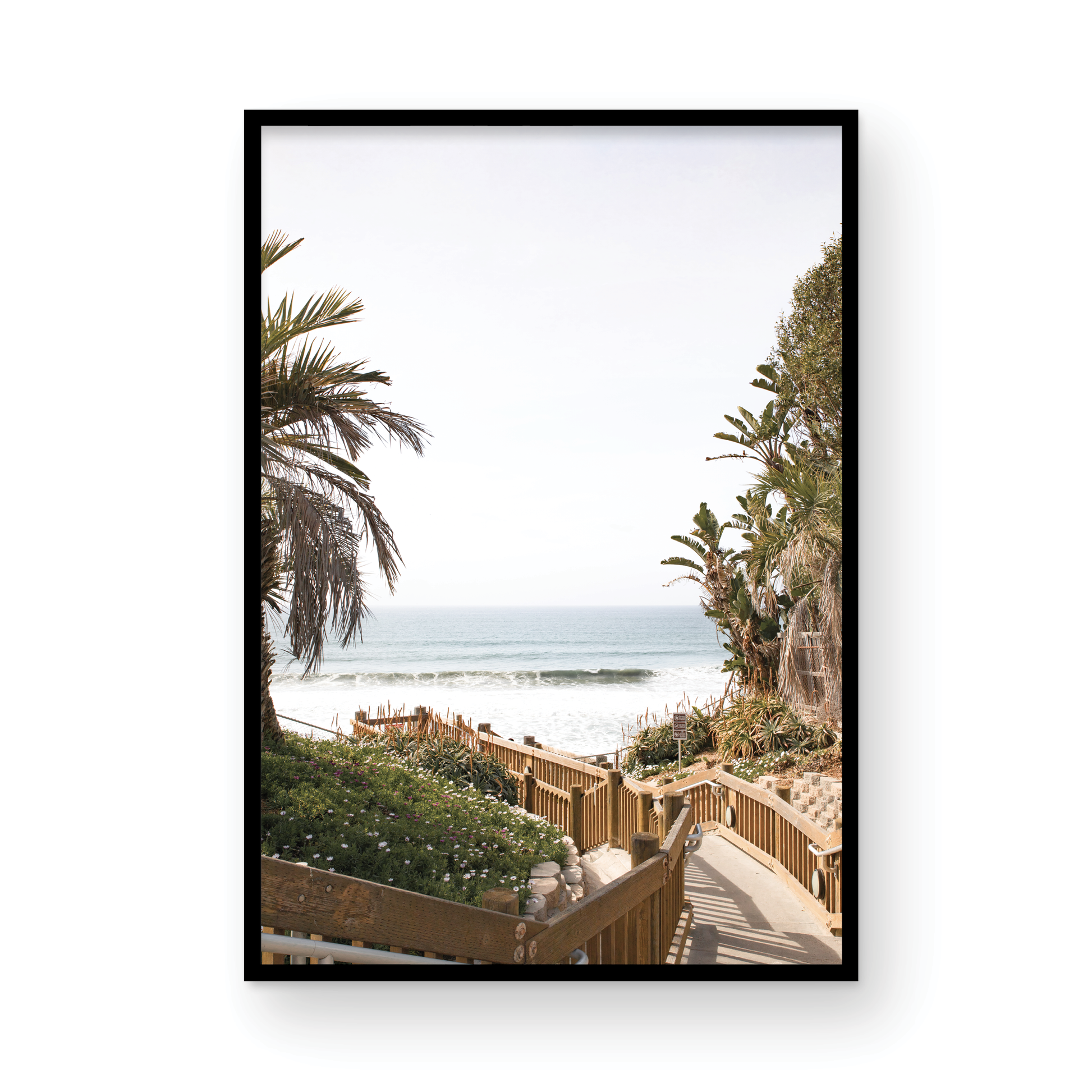 Vertical coastal wall print featuring a stairway leading down to a beach with palm trees and ocean view. Photograph in minimalist mock up.