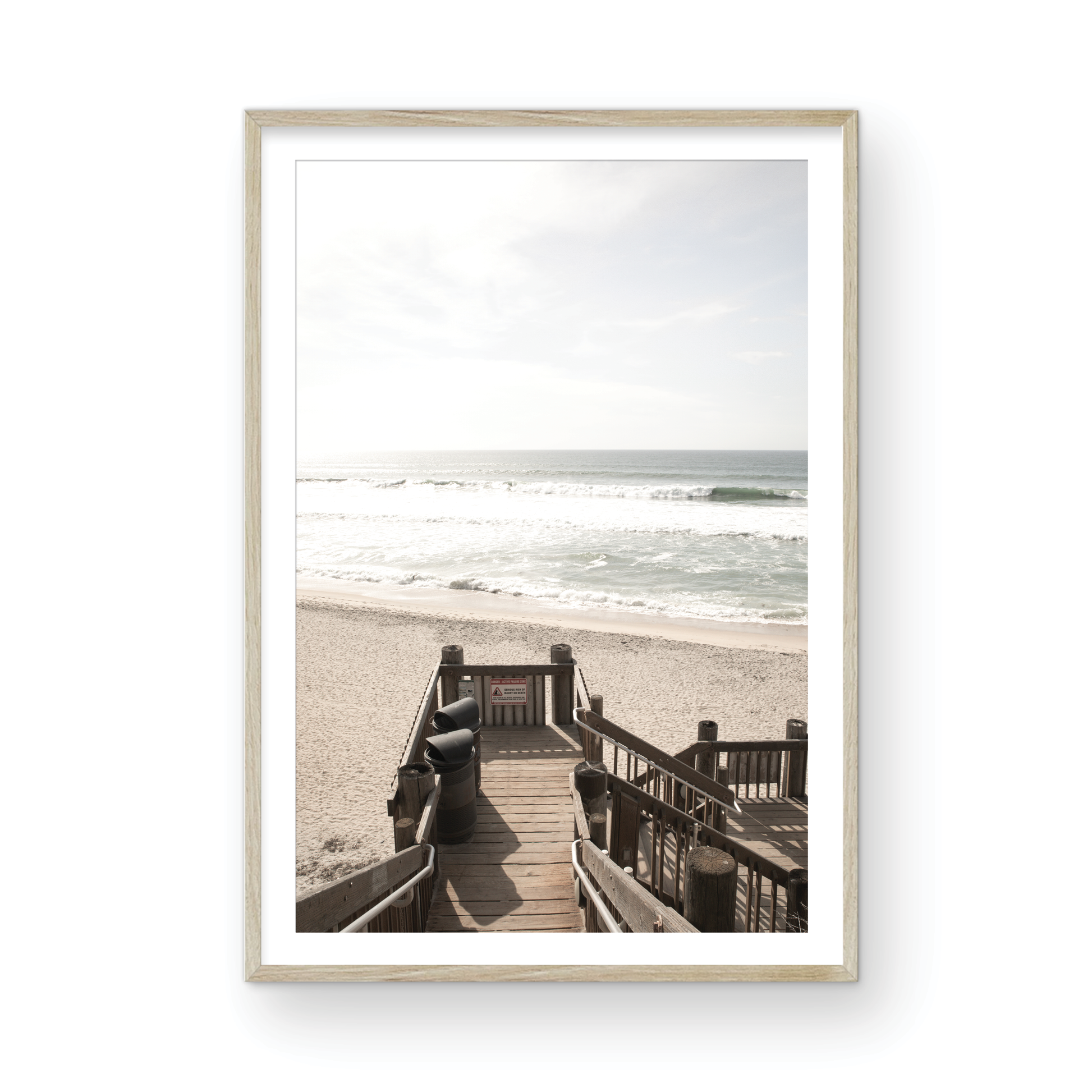 Vertical coastal wall print featuring a stairway leading down to a beach, overlooking an ocean view. Photograph in minimalist mock up.