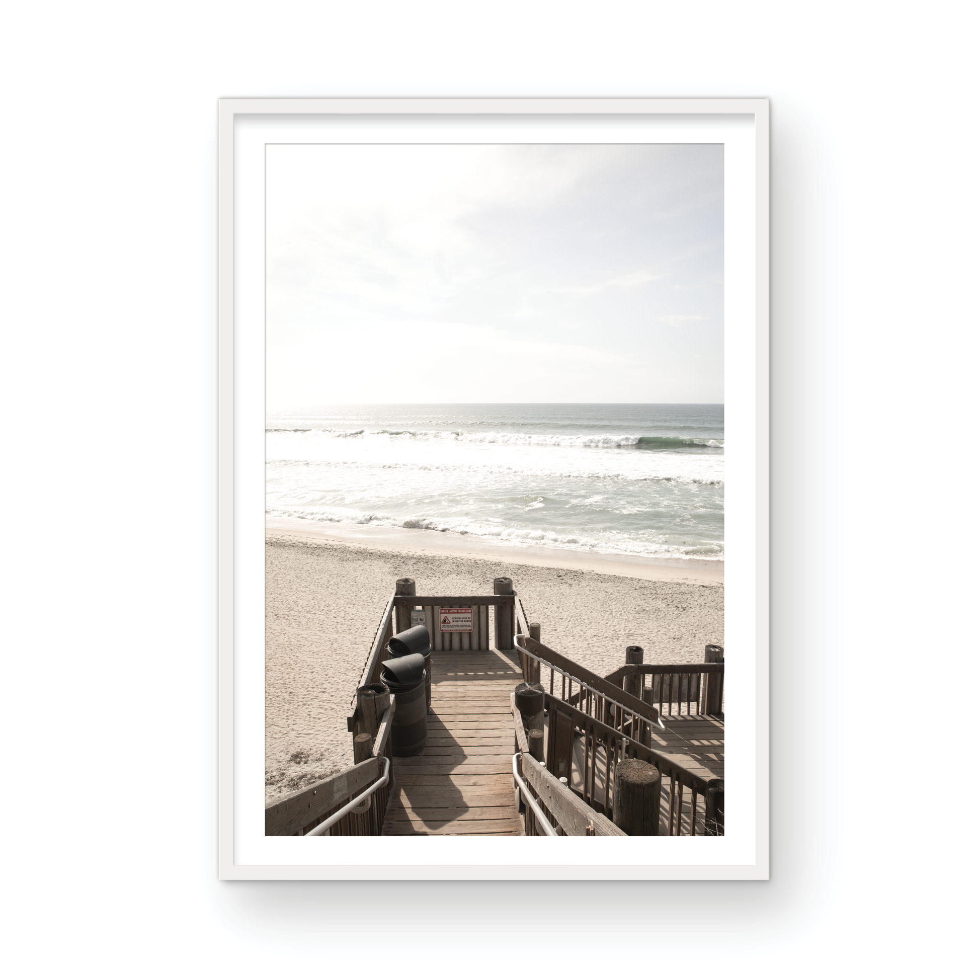 Vertical coastal wall print featuring a stairway leading down to a beach, overlooking an ocean view. Photograph in minimalist mock up.